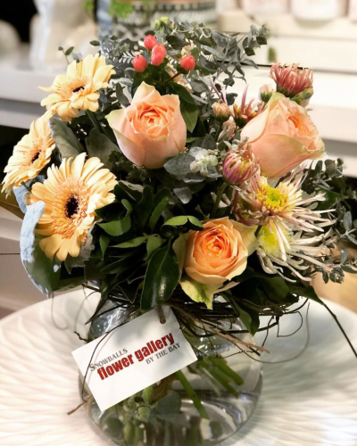 Peach Dream - A delightful posy in soft peach tones, arranged with roses seasonal flowers. This sweet and elegant design comes in a clear glass bowl, making it a versatile gift for any occasion.