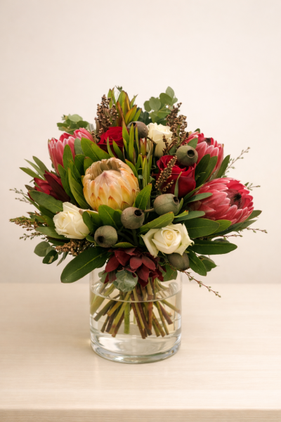 Winter Wonder - A beautiful range of winter's native flowers and a couple of roses to add a pop of richness to the texture of the proteas. Designed in a vase so that this arrangement is ready to be displayed as the recipient receives such a gift of beauty.