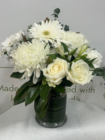 Eco Elegance - Elevate any space with this elegant eco vase arrangement of white flowers, featuring a luxurious blend of fresh white roses, chrysanthemum disbuds, daisy chrysanthemums, and a striking gerbera-style bloom. Designed in a clear recycled glass eco vase , this arrangement combines timeless beauty with an environmentally conscious touch.

Perfect for sympathy flowers, birthday gifts, anniversaries, and same‑day flower delivery, this classic white bouquet offers a clean, modern aesthetic that suits any home or office.
Crafted with premium seasonal blooms, this white flower arrangement is ideal for customers seeking sustainable floral designs, long-lasting flowers, and elegant white bouquets for every occasion.