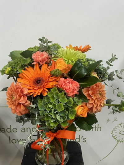 Autumn Abundance - Bring the warmth of the season indoors with this vibrant autumn eco‑friendly vase arrangement. Bursting with rich seasonal colour, this design features bold orange gerberas, warm peach dahlias, lush green hydrangea, bright orange spray roses, and soft coral carnations. Fresh eucalyptus and deep green foliage add natural texture and movement, enhancing the arrangement’s earthy autumn palette
Crafted with fresh, premium blooms, this arrangement is a beautiful choice for anyone seeking autumn flower delivered, that captures the essence of the season.